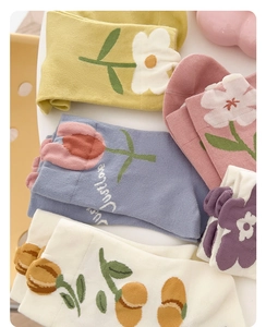 Dettaglio di calze in cotone colorate con motivi floreali 3D e scritta Just Love