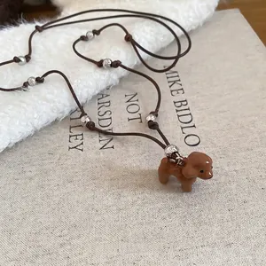 Collier mignon avec pendentif caniche marron et perles argentées sur cordon marron