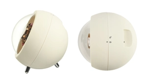 Detail view of spherical watch winder with cream plastic shell and metal feet stand
