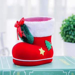 Detail of red flocked Christmas boot container with green wreath and festive bow