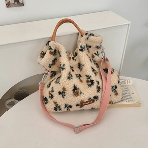 Detailed close-up of sherpa fleece floral bag with woven handles and a leather label