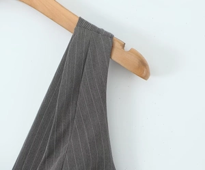 Dettaglio ravvicinato della tuta grigio scuro a righe su gruccia in legno con trama fine