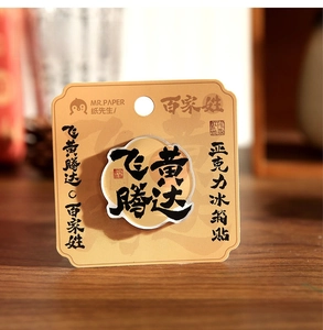 Close-up of acrylic fridge magnet with black calligraphy on a wooden surface