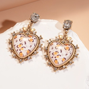 Macro view of leopard heart earring with rhinestones on a textured stone surface