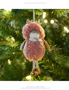 Pink plush reindeer ornament with golden antlers and star on a warm Christmas tree background