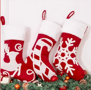 Detailed embroidery of reindeer and candy cane patterns on festive red Christmas stockings