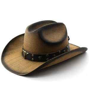 Straw cowboy hat with brown leather band and bull head ornament on white background