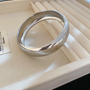 Gros plan d'un bracelet géométrique argenté poli miroir sur un plateau à bijoux chic