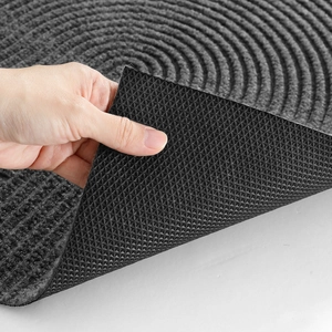 Close-up of black door mat showing concentric circle texture and diamond non-slip backing