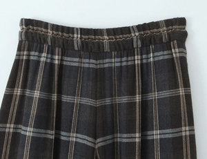 Detail of checkered trousers waist with elastic band and woven fabric texture
