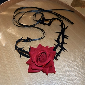 Nahaufnahme eines dunklen Gothic-Chokers mit tiefroter Samtrose und schwarzen Dornen