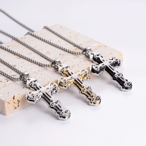 Three-piece set of layered stainless steel cross pendants in silver, gold, and black colors