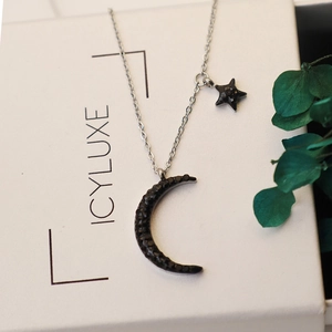 Silver necklace with black rhinestone crescent moon and star pendant on luxury white box