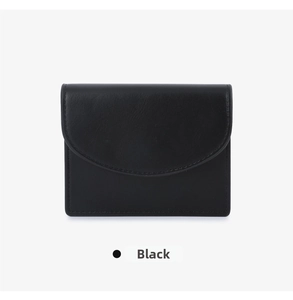 Detail of minimalist black leather card holder with textured semicircular flap design