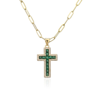 Close-up of gold paperclip chain necklace with emerald green zircon cross pendant