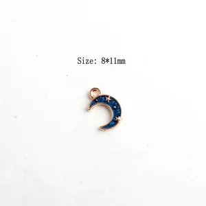 Close-up of a blue enamel moon charm with gold plating and stars, size 8x11mm for DIY