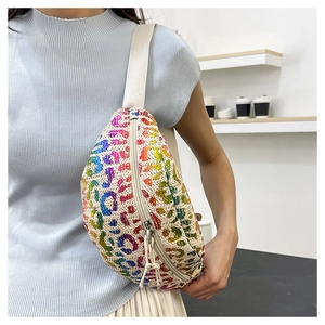 Detailed close-up of rainbow leopard print straw fanny pack with woven texture and strap