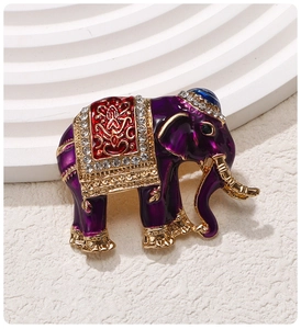 Detail of vintage purple elephant brooch with golden saddle and sparkling crystals