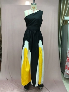 Detail of one-shoulder maxi dress with black bodice and yellow-white color block skirt