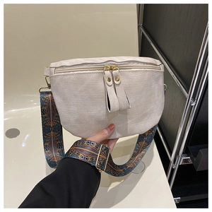 Détail du sac bandoulière blanc cassé avec une large sangle ethnique brodée colorée