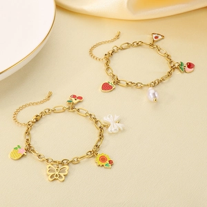 Détail de bracelets dorés avec breloques émaillées de fraises et de tournesols colorés