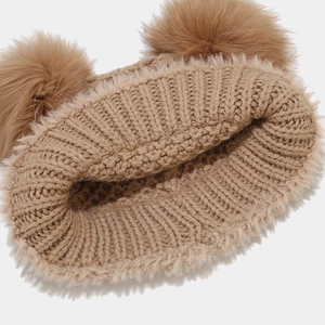 Detail view of khaki knit hat featuring plush thickened fleece lining and double fur pom-poms