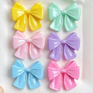 Detailed view of colorful resin bow charms in a six-piece set for DIY hair accessories