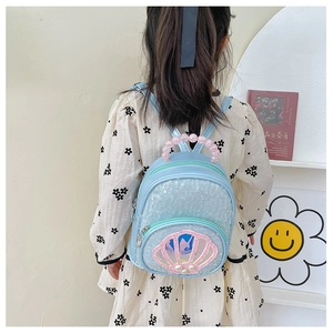 Close-up of sky blue sequin kids backpack with shell pocket and pearl bead handle