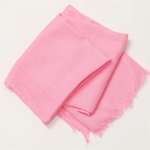Detail showing the natural texture of pink cotton linen scarf with frayed tassel edges