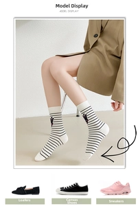 Detail of white cotton crew socks with black stripes and cartoon bear embroidery