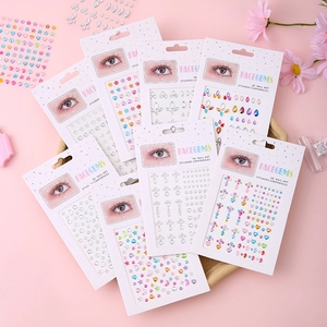 Various face gems and 3D nail art stickers with pearls and hearts on a pink background