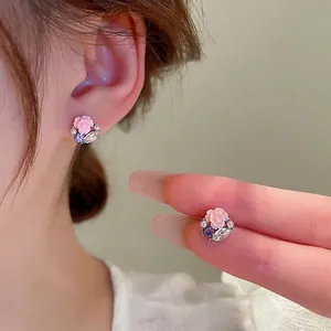 Floral stud earrings featuring a pink resin rose, purple zircon, and white pearls