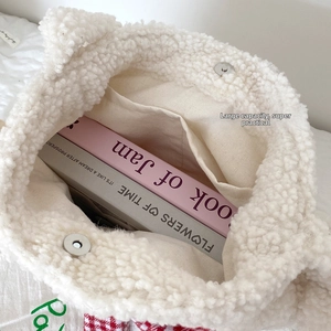 Interior detail of white plush tote bag with magnetic clasp and canvas lining