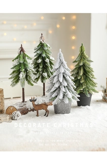 Detailed view of snowy mini Christmas trees with a small deer and warm festive lights