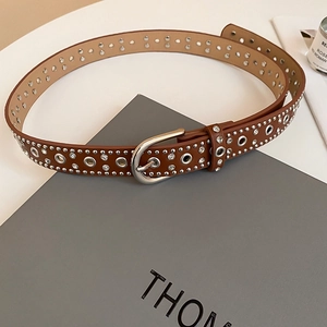 Close-up of brown leather belt with silver rivets, rhinestones and horseshoe buckle