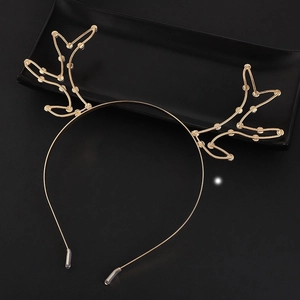Detailed view of gold metal reindeer antlers headband with protective sleeve on black tray