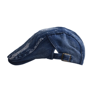 Detail of distressed navy denim ivy cap showing frayed edges and bronze metal buckle