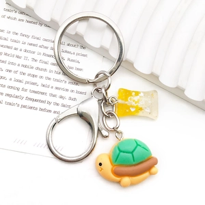 Cute green turtle keychain with a yellow glitter heart candy charm on a metal ring