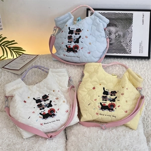 Détails du matelassage en cœur et broderie chat sur sacs bleus, blancs et jaunes