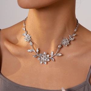 Close-up detail of silver metal leaf and flower necklace with intricate textures