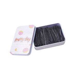 Black bobby pins set in a cute pink doughnut metal tin for hair styling and storage
