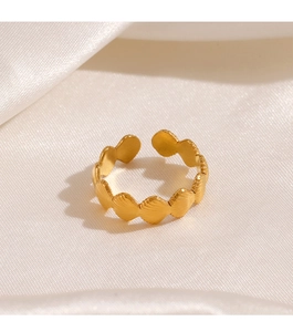 Detail of a gold adjustable ring featuring a textured scallop shell design on white silk