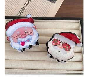 Detail of Christmas Santa Claus hair claws with cartoon design on beige velvet display