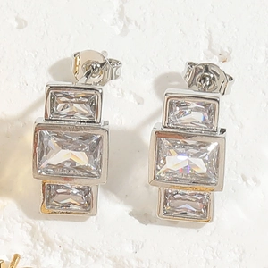 Close-up of geometric silver stud earrings with triple stacked rectangular cubic zirconia