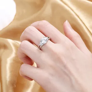 Close-up of heart-shaped zircon ring on gold silk fabric, detailed engagement jewelry