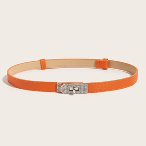 Close-up of orange cross-grain leather skinny belt with silver diamond-set turn-lock buckle