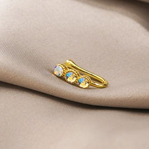 Close-up of golden U-shaped non-piercing nose clip with three iridescent rhinestones