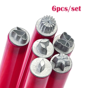 Macro view of 6-piece leather stamping tool set with red handles and metal flower patterns