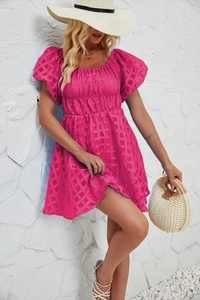 Détail de la robe fuchsia à manches bouffantes avec tissu gaufré à carreaux et col carré