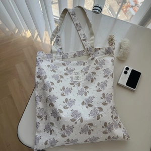 Close-up of floral cotton tote bag texture with lilac print and decorative 3D dots